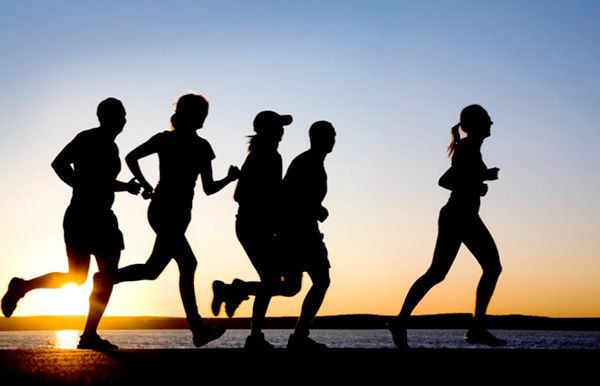 Grupo de personas corriendo al lado del mar